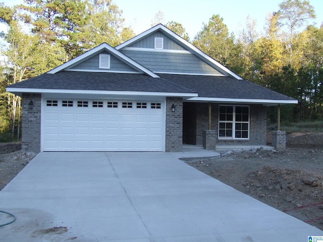 view of front of home with an attached garage, brick siding, and driveway