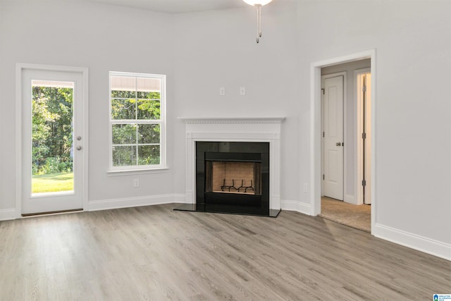 unfurnished living room featuring a high ceiling and hardwood / wood-style floors