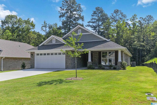 craftsman-style house with a garage, central AC unit, and a front lawn