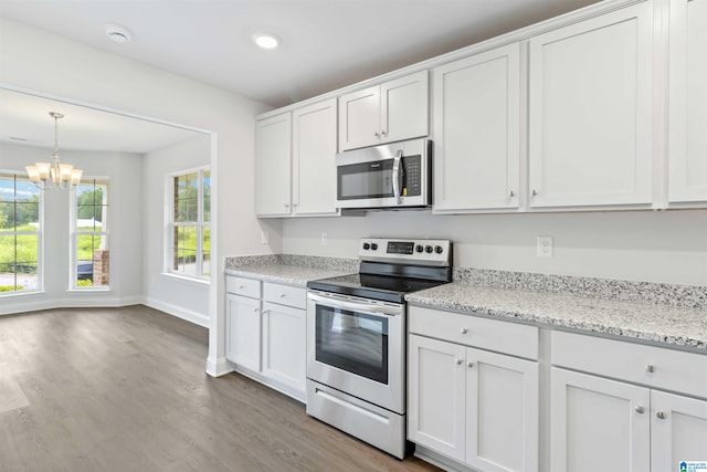 kitchen featuring white cabinetry, hardwood / wood-style floors, a chandelier, and appliances with stainless steel finishes