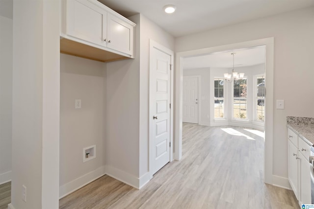 interior space featuring pendant lighting, light stone counters, white cabinetry, and light hardwood / wood-style flooring