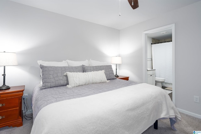 carpeted bedroom with ceiling fan and ensuite bath