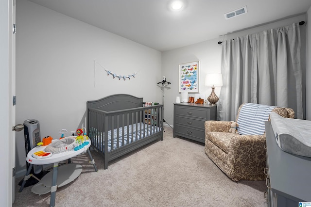 bedroom featuring a crib and light colored carpet