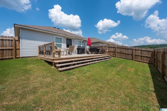 rear view of house with a deck and a lawn