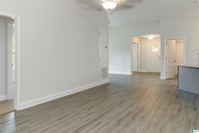 unfurnished living room featuring ceiling fan and hardwood / wood-style flooring