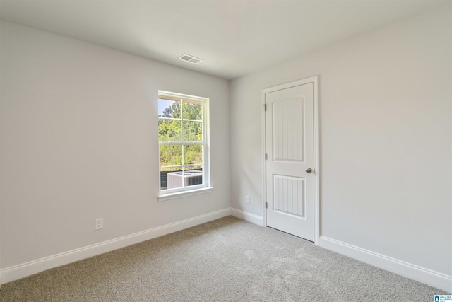 spare room featuring light colored carpet