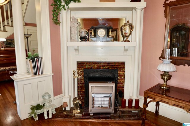 interior details featuring a fireplace, decorative columns, and hardwood / wood-style floors