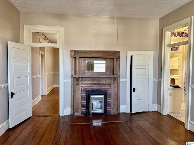 401 SW 8th St, Cullman, AL 35055 - unfurnished living room featuring baseboards, a textured ceiling, a fireplace, and dark wood-style flooring
