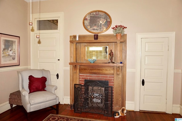 sitting room featuring a fireplace and dark wood-type flooring