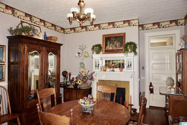 dining room featuring a notable chandelier, dark hardwood / wood-style flooring, and a textured ceiling