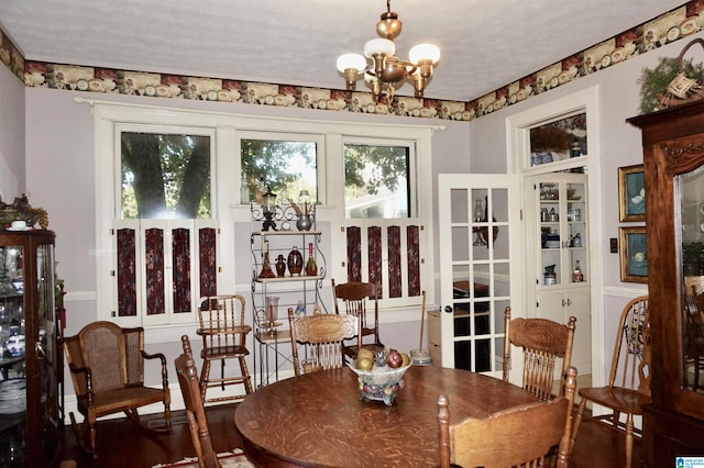 dining area featuring a textured ceiling and an inviting chandelier