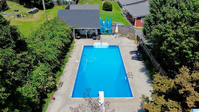 view of pool featuring a patio area, a lawn, and a diving board