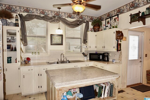 kitchen featuring ceiling fan, light tile patterned floors, sink, and white cabinetry