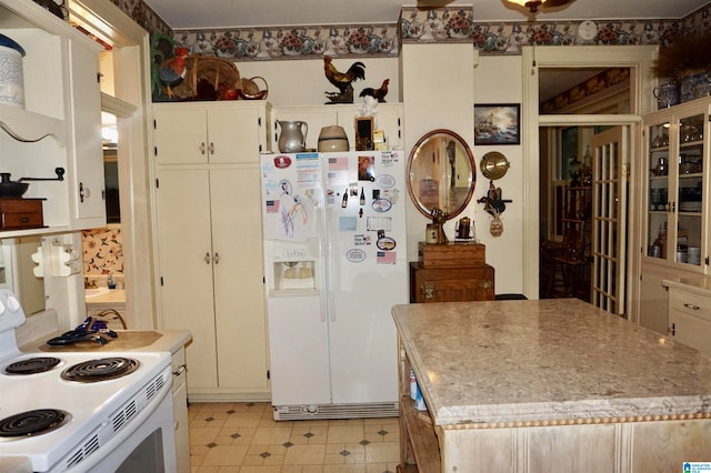 kitchen featuring light tile patterned flooring, stove, and white refrigerator with ice dispenser