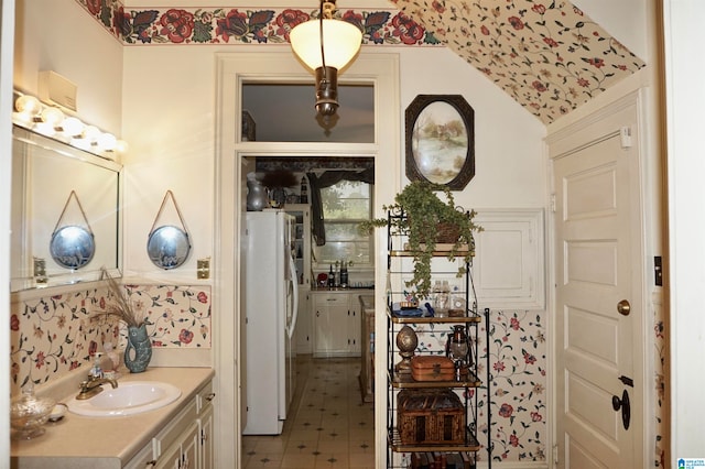 bathroom with tile patterned floors, vaulted ceiling, and vanity