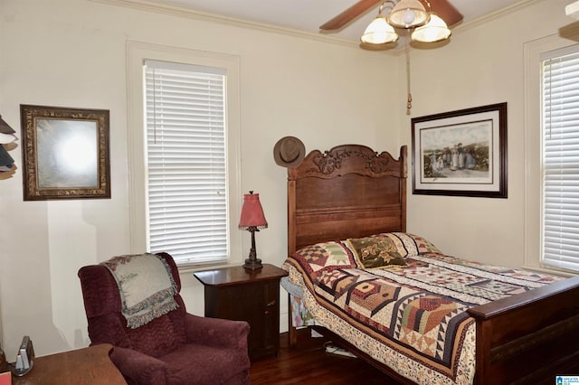 bedroom with ornamental molding, dark wood-type flooring, and ceiling fan