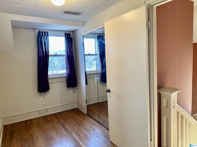 401 SW 8th St, Cullman, AL 35055 - unfurnished bedroom with visible vents, a textured ceiling, hardwood / wood-style floors, a closet, and baseboards