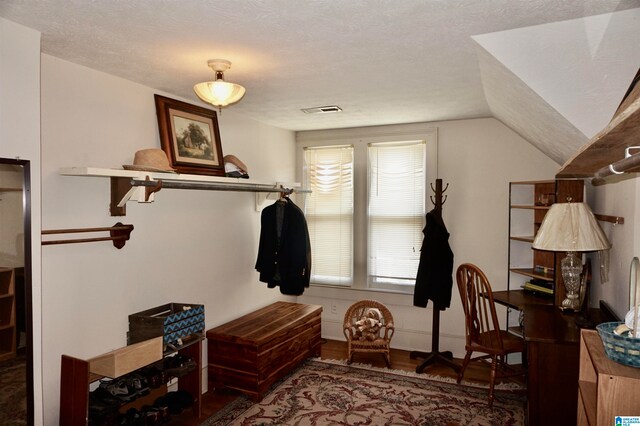 mudroom with hardwood / wood-style floors, a textured ceiling, and lofted ceiling