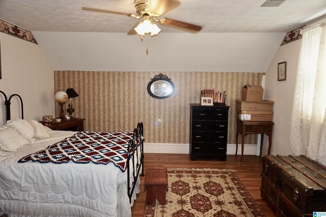 bedroom featuring lofted ceiling, dark hardwood / wood-style flooring, and ceiling fan