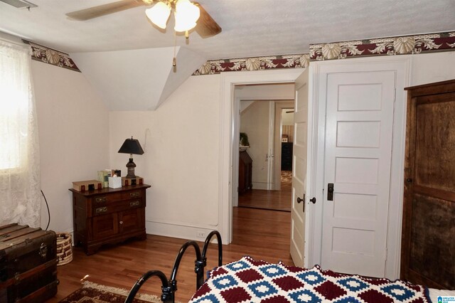 bedroom with ceiling fan, hardwood / wood-style flooring, and lofted ceiling