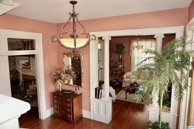 interior space with decorative columns and dark hardwood / wood-style floors