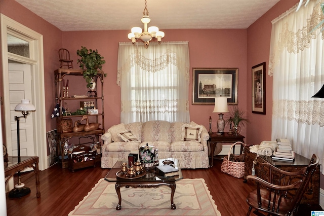 living room featuring dark hardwood / wood-style flooring and an inviting chandelier