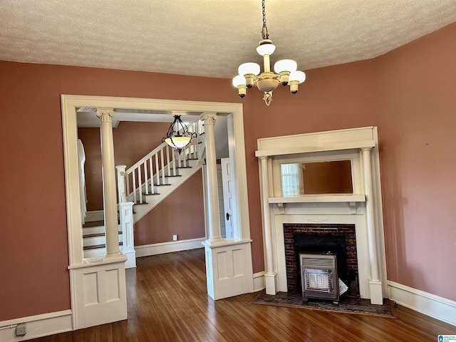 401 SW 8th St, Cullman, AL 35055 - unfurnished living room with baseboards, stairway, dark wood-style floors, a notable chandelier, and a textured ceiling