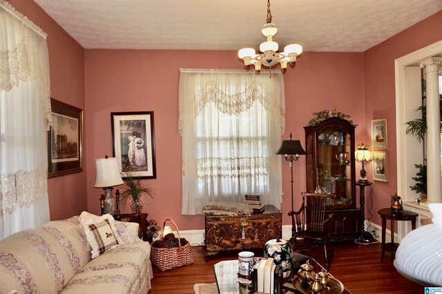 living room with dark wood-type flooring and a chandelier