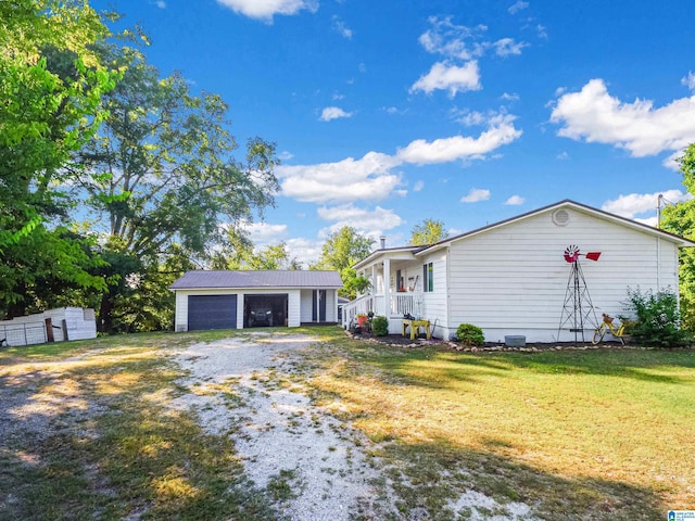 single story home with covered porch, a front lawn, an outdoor structure, and a detached garage