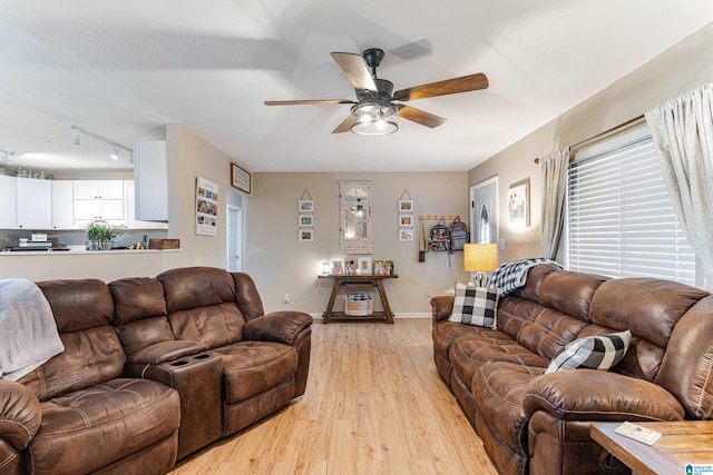 living room featuring a ceiling fan, light wood-type flooring, rail lighting, and baseboards