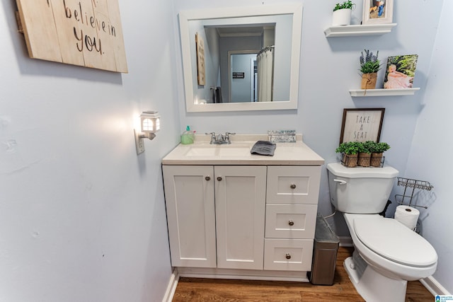 full bathroom featuring toilet, baseboards, wood finished floors, and vanity