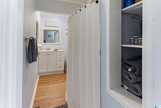 full bathroom with wood finished floors, vanity, and baseboards