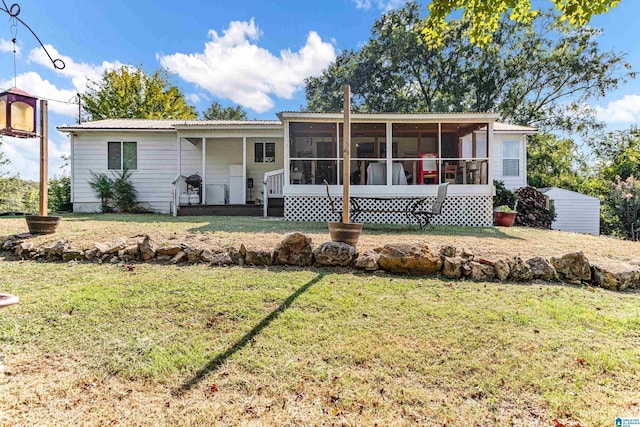 view of front facade with a sunroom, metal roof, and a front lawn