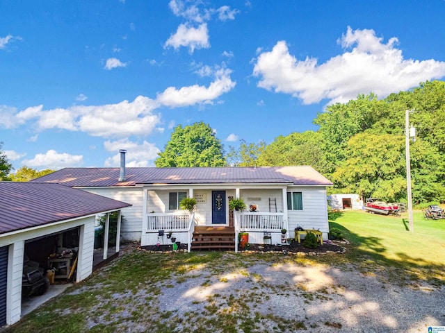 view of front of home with a front yard, covered porch, and metal roof