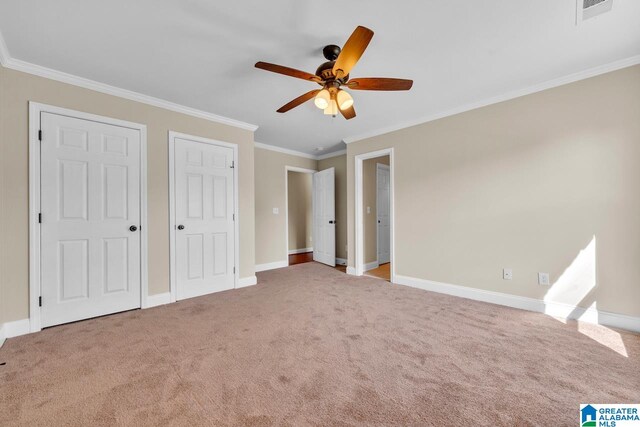 unfurnished bedroom featuring ceiling fan, crown molding, and carpet flooring