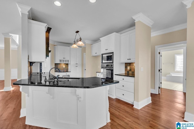 kitchen with light wood-type flooring, white cabinets, oven, and backsplash