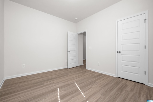 unfurnished bedroom with light hardwood / wood-style floors and a closet