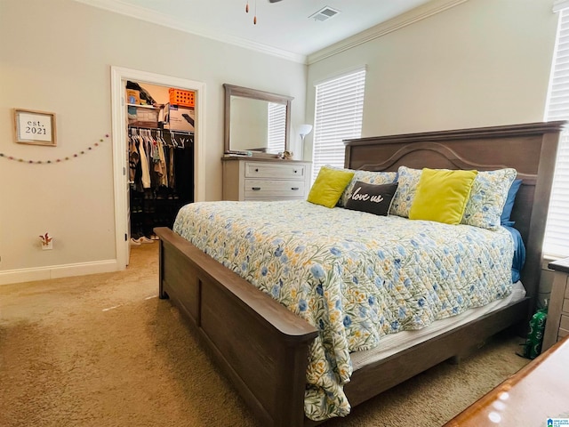 carpeted bedroom with a closet, a spacious closet, and crown molding