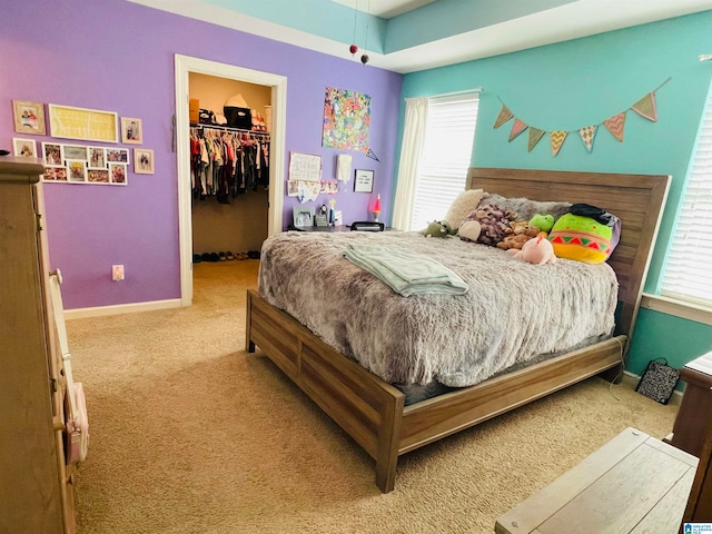 carpeted bedroom featuring a spacious closet, a closet, and multiple windows