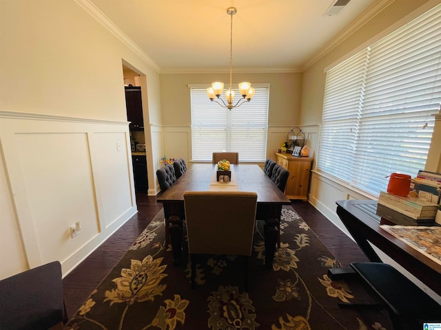 dining space featuring a wealth of natural light, ornamental molding, a chandelier, and dark hardwood / wood-style flooring