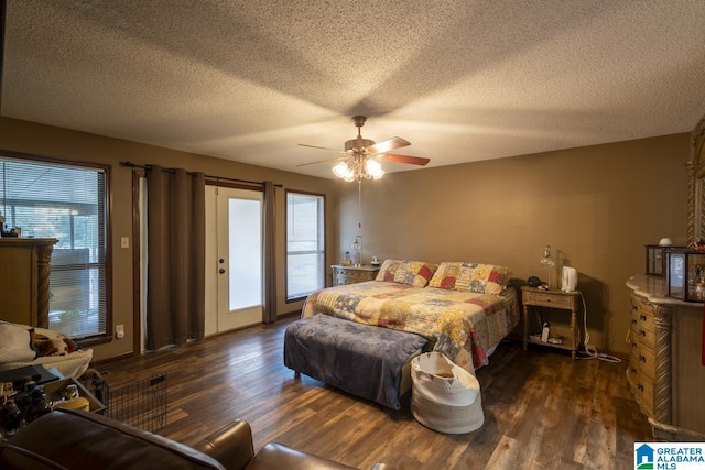 bedroom with a ceiling fan, access to outside, dark wood-style flooring, and a textured ceiling