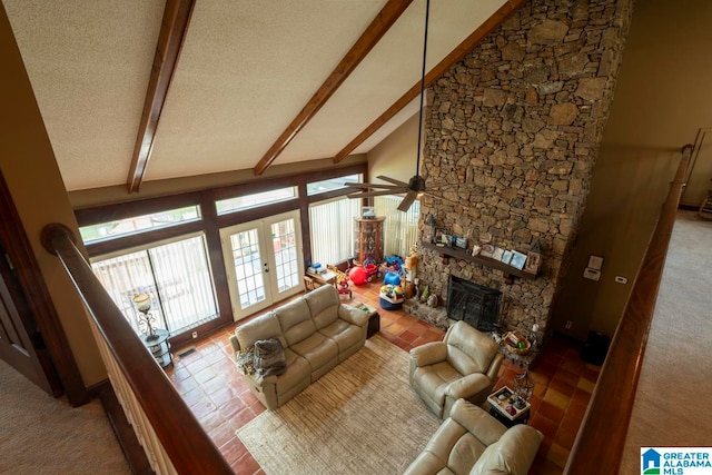 living room featuring high vaulted ceiling, ceiling fan, a fireplace, beam ceiling, and a textured ceiling