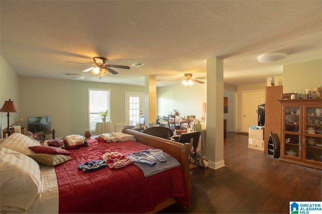 bedroom with ceiling fan, a textured ceiling, and dark hardwood / wood-style flooring