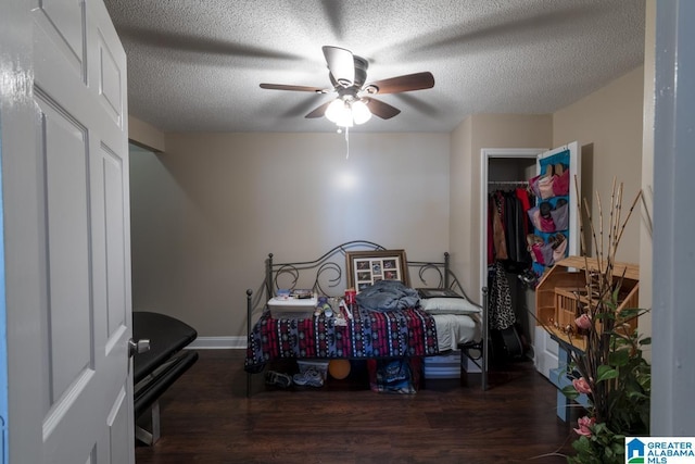 bedroom with baseboards, a ceiling fan, dark wood finished floors, and a textured ceiling