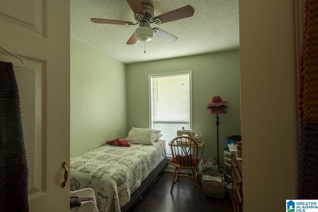 bedroom featuring dark wood-style floors, ceiling fan, and a textured ceiling