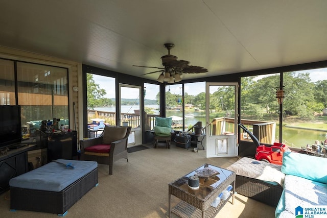 sunroom / solarium with ceiling fan and a water view