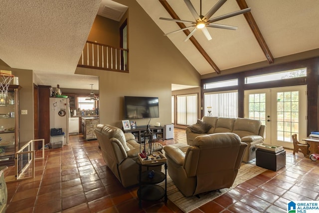 living area with a textured ceiling, high vaulted ceiling, french doors, and ceiling fan