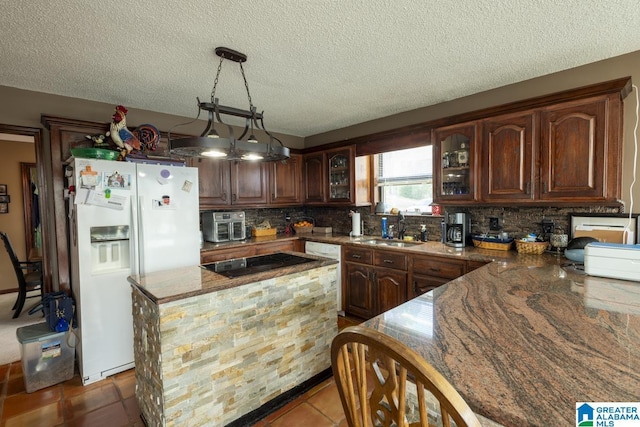 kitchen featuring hanging light fixtures, backsplash, glass insert cabinets, a sink, and white appliances