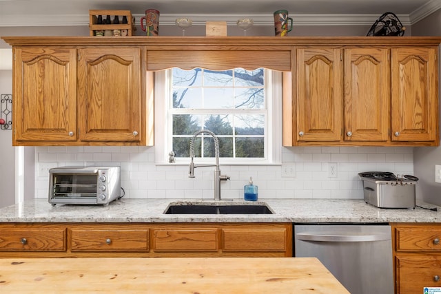 kitchen with tasteful backsplash, sink, ornamental molding, stainless steel dishwasher, and light stone counters