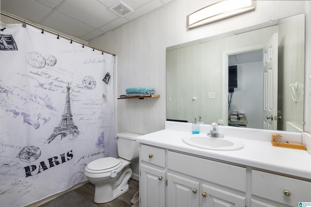 bathroom featuring hardwood / wood-style flooring, a paneled ceiling, vanity, and toilet